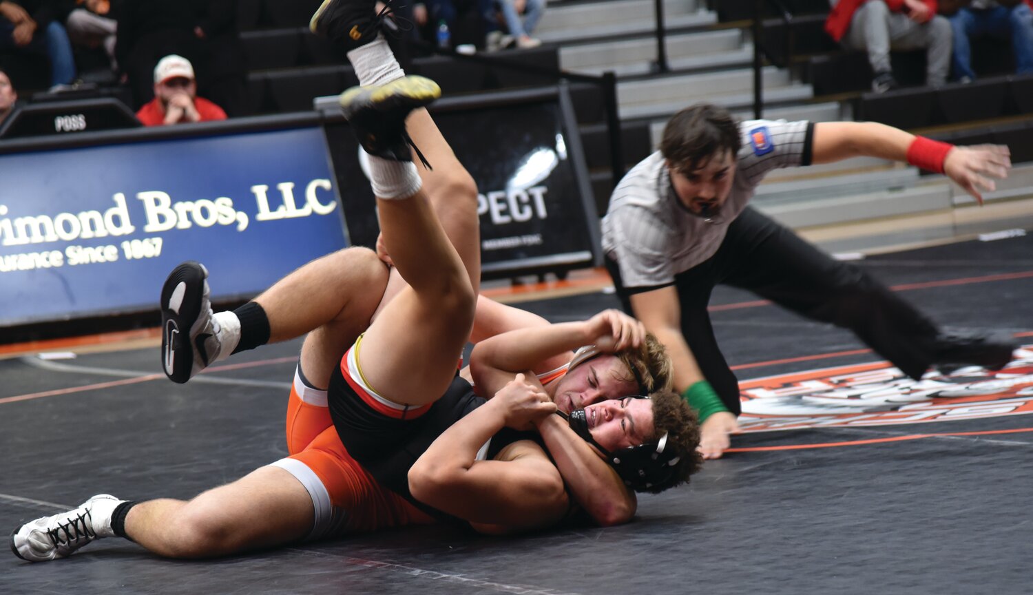 Ethan Curl tightens his grip on his opponent, looking to earn a pin. Curl and the Tigers opened their season with a victory against the Charleston Trojans.